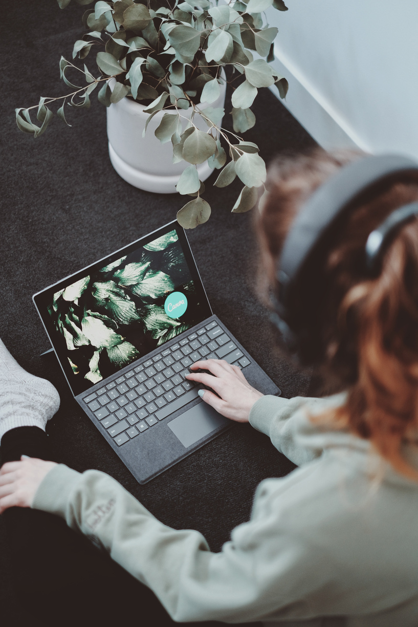 Woman with headphones working on laptop